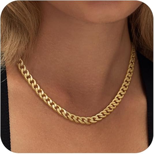 Närbild på ett guldfärgat chunky cuban link-halsband runt halsen