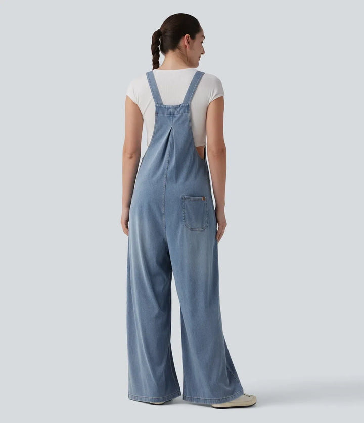 Kvinna i blå draperad baggy overall bakifrån med fickdetalj
