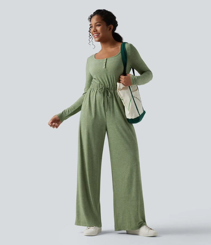 Grön jumpsuit för dam med lång ärm upphängd på galge