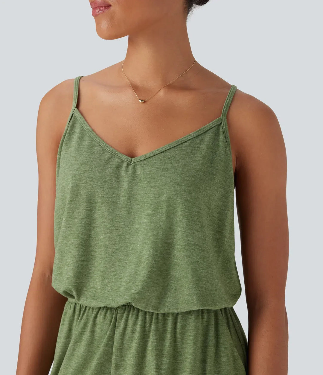 Grön jumpsuit för dam med praktiska fickor, sedd bakifrån för bekväm passform.