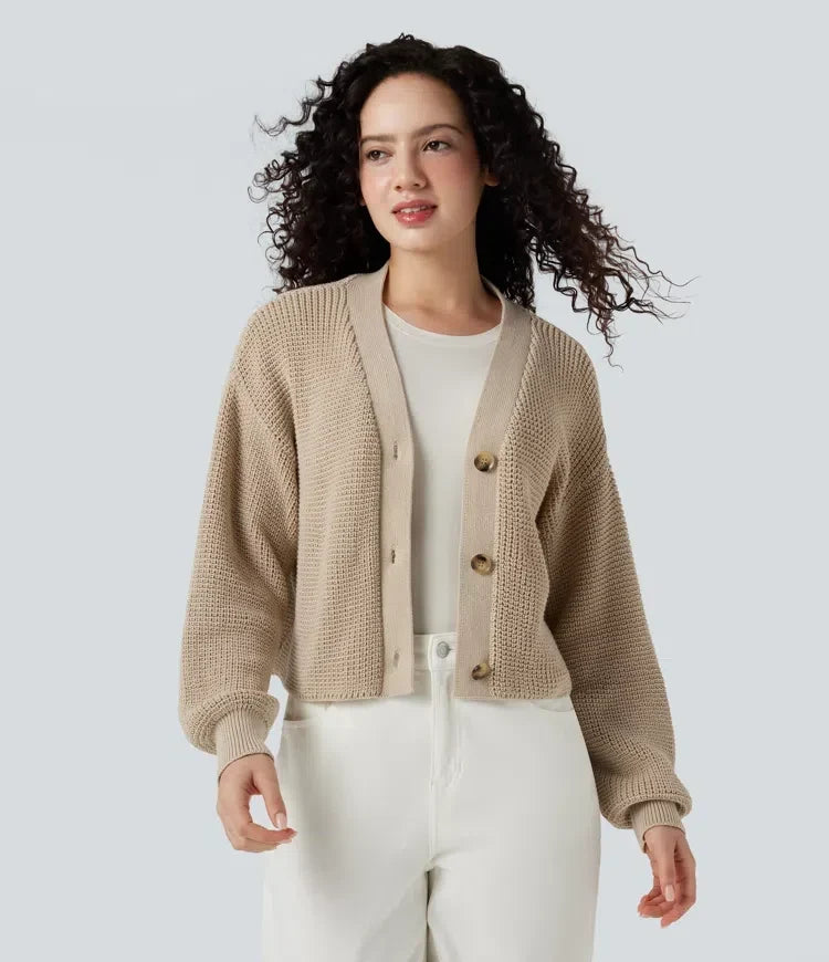 Kvinna som bär beige cardigan med våffelstruktur och v-ringning framifrån