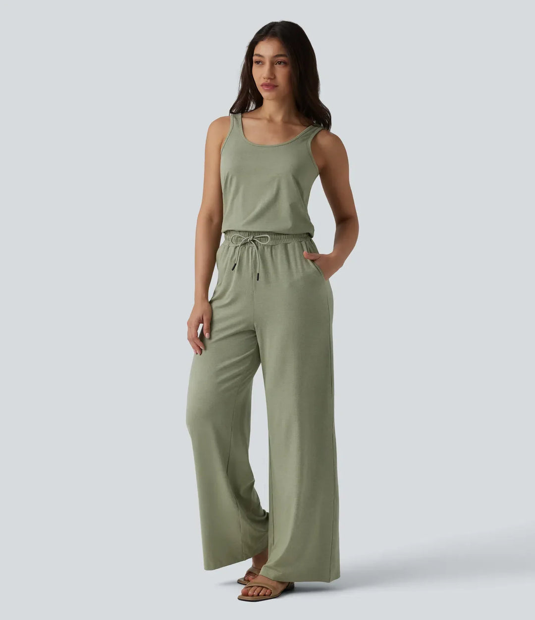 Helkroppsbild framifrån av modell i grön ledig jumpsuit