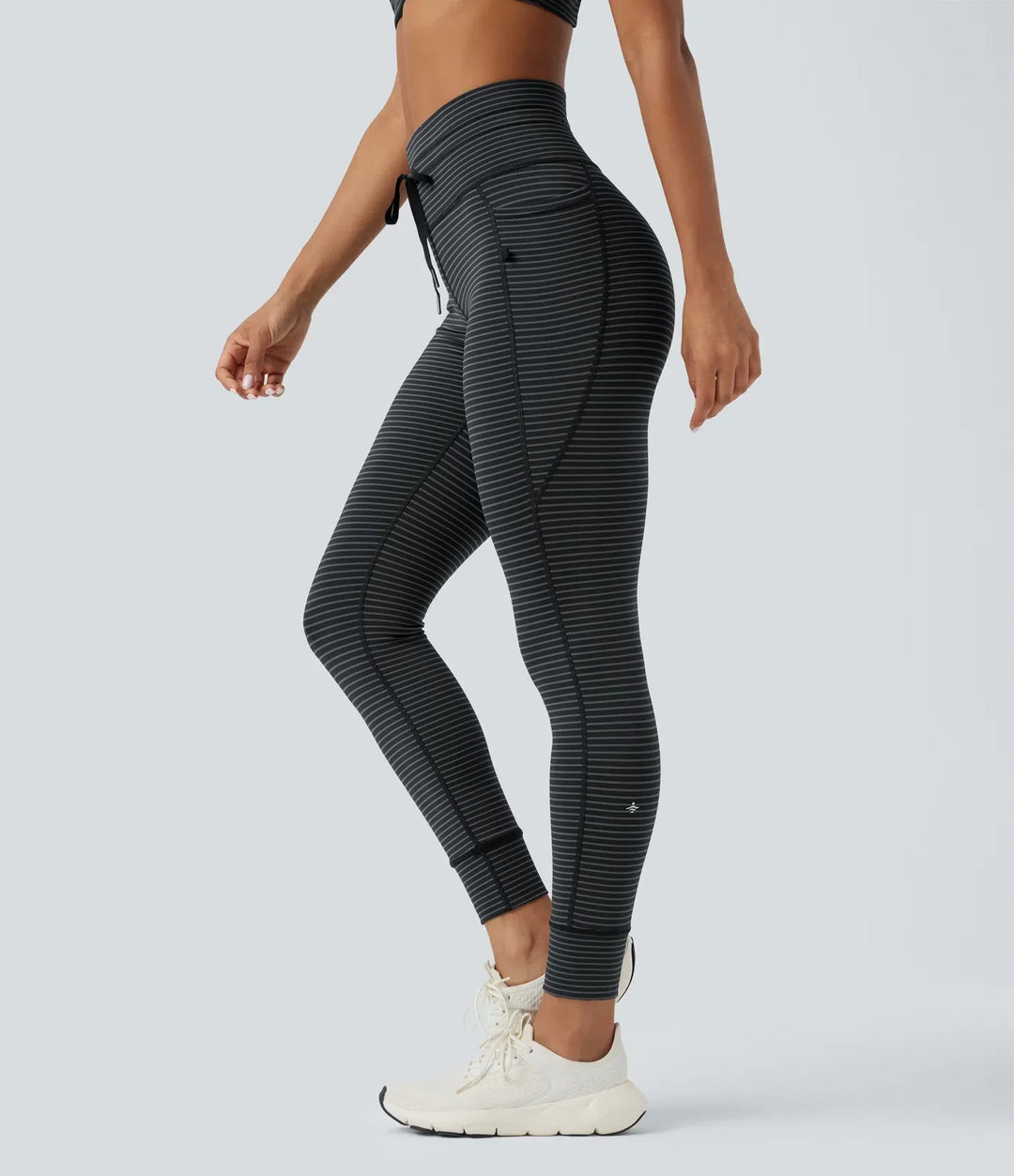 Modell i bekväma randiga träningskläder och yogaleggings med hög midja