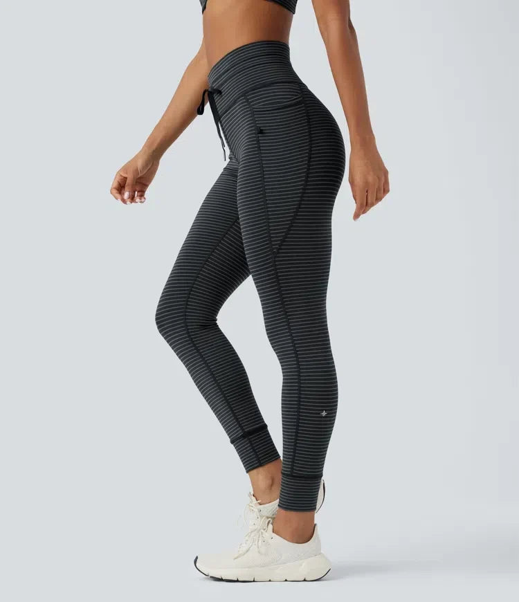 Dam i högmidjad randig yogaleggings med fickor och dragsko från sidan