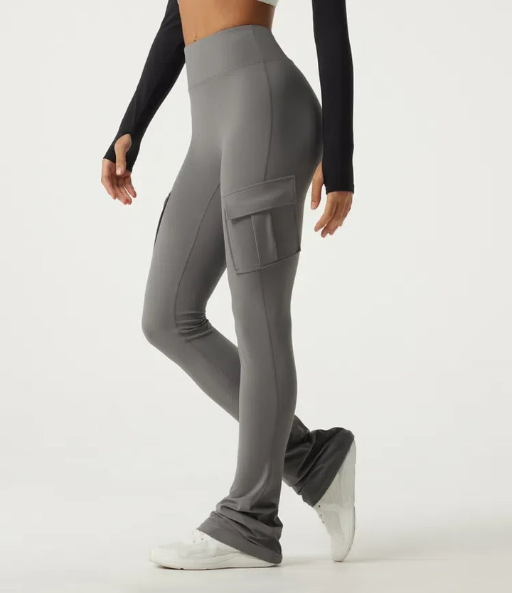 Dam i grå högmidjade bootcut yogaleggings med fickor från sidan