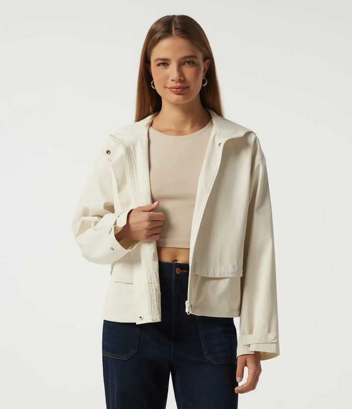 Framifrån på en öppen beige damjacka med huva och praktiska fickor
