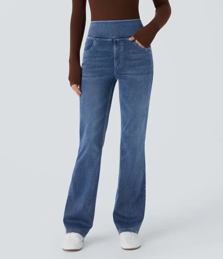 Framifrån av dam i blå bootcut jeans med hög midja och brun överdel