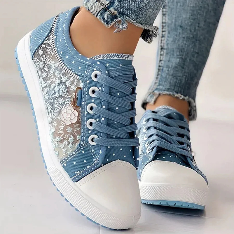 Närbild på textur och spetsdetaljer på blå dam sneakers
