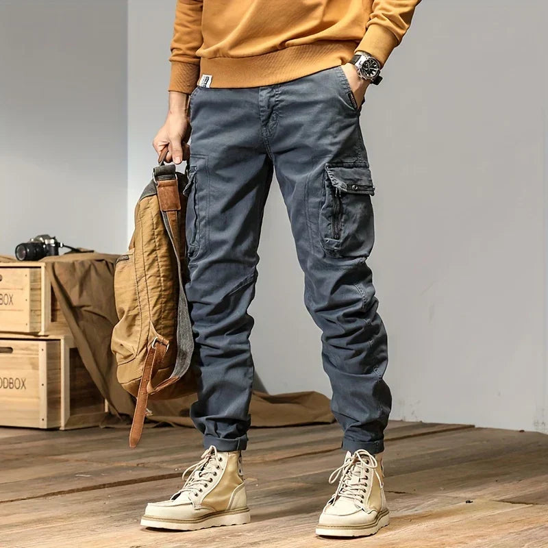 Man i grå cargo joggers som matchar en modern streetwear-stil