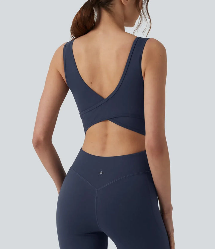 Utsvängd träningsjumpsuit för dam i ryggvinkel med fitnessdesign