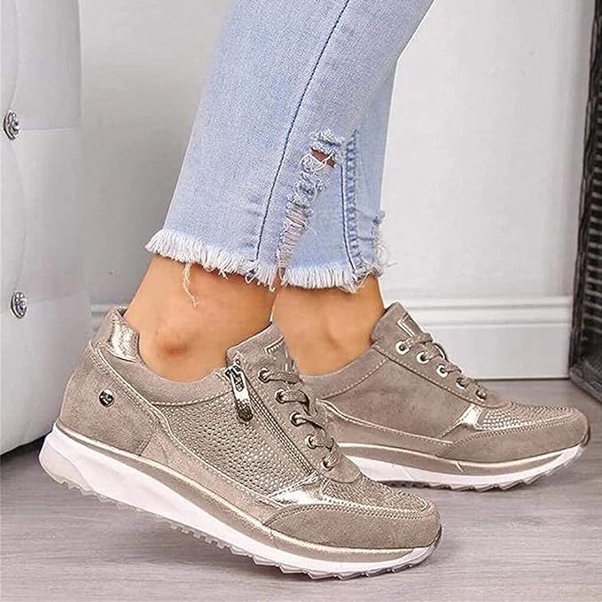 Beige kilklackssneakers med dragkedja på damfot