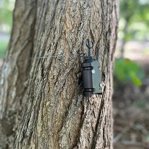 Perimeterlarm monterat på ett träd i skogen med tråd