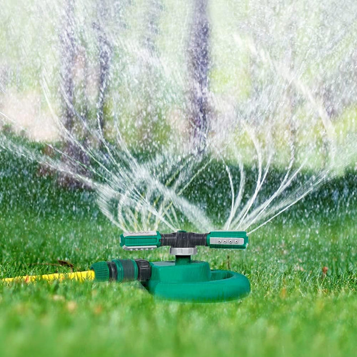 Vattensprinkler som sprider vatten i en grön trädgård