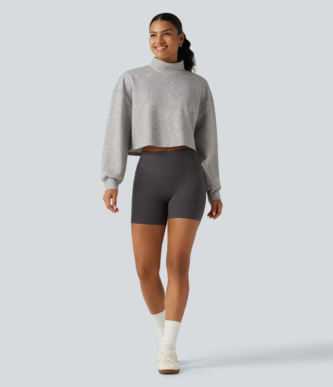 Helbild på dam i långärmad croppad sweatshirt med hög krage