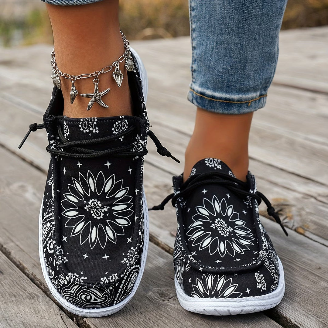 Närbild på svarta Catherine sneakers med mönstrad ovandel på utomhusgolv