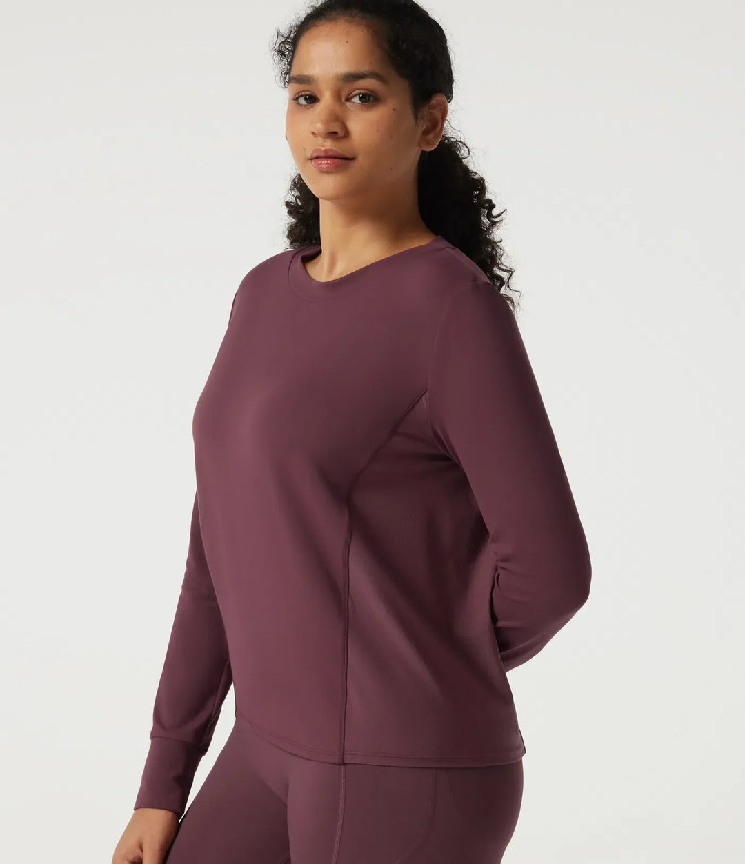 Sida av mörklila träningssweatshirt som visar den figurnära och följsamma passformen