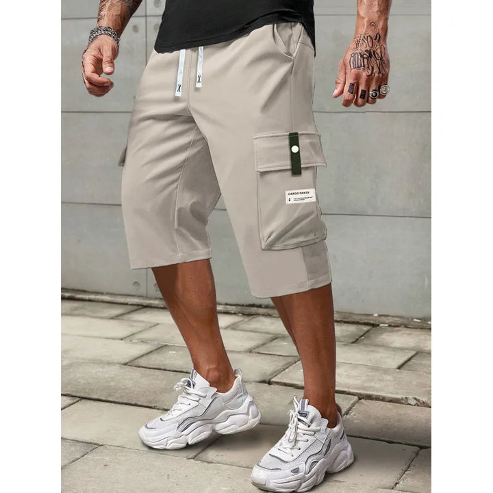 Man i kaki cargoshorts med dragsko i midjan utomhus