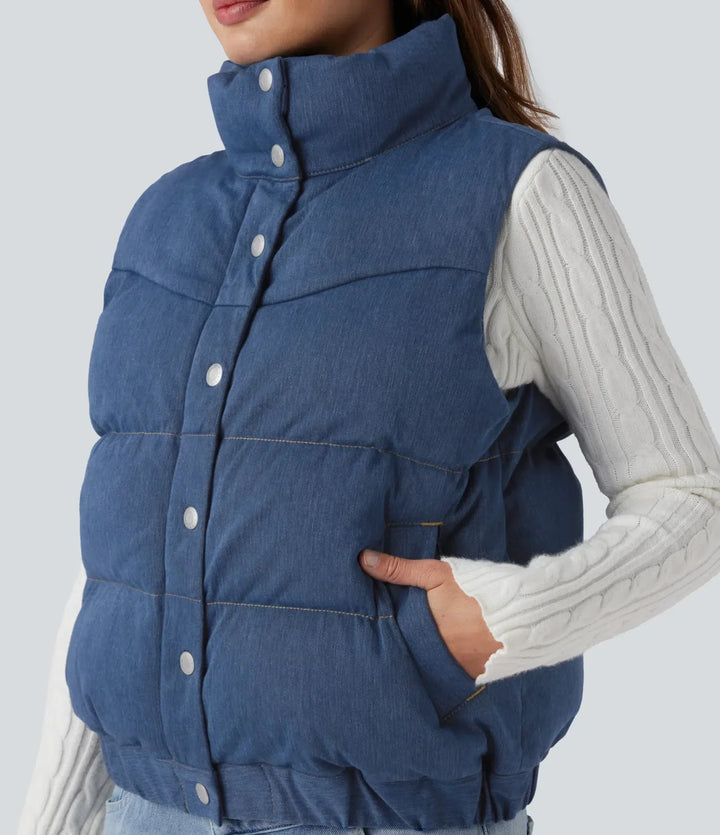 Denimblå damväst med vaddering och praktisk ståkrage sedd bakifrån