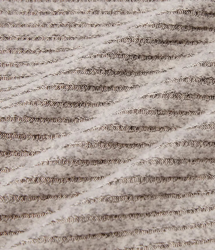 Närbild på ribbad textur och hög hals på damtopp med puffärm
