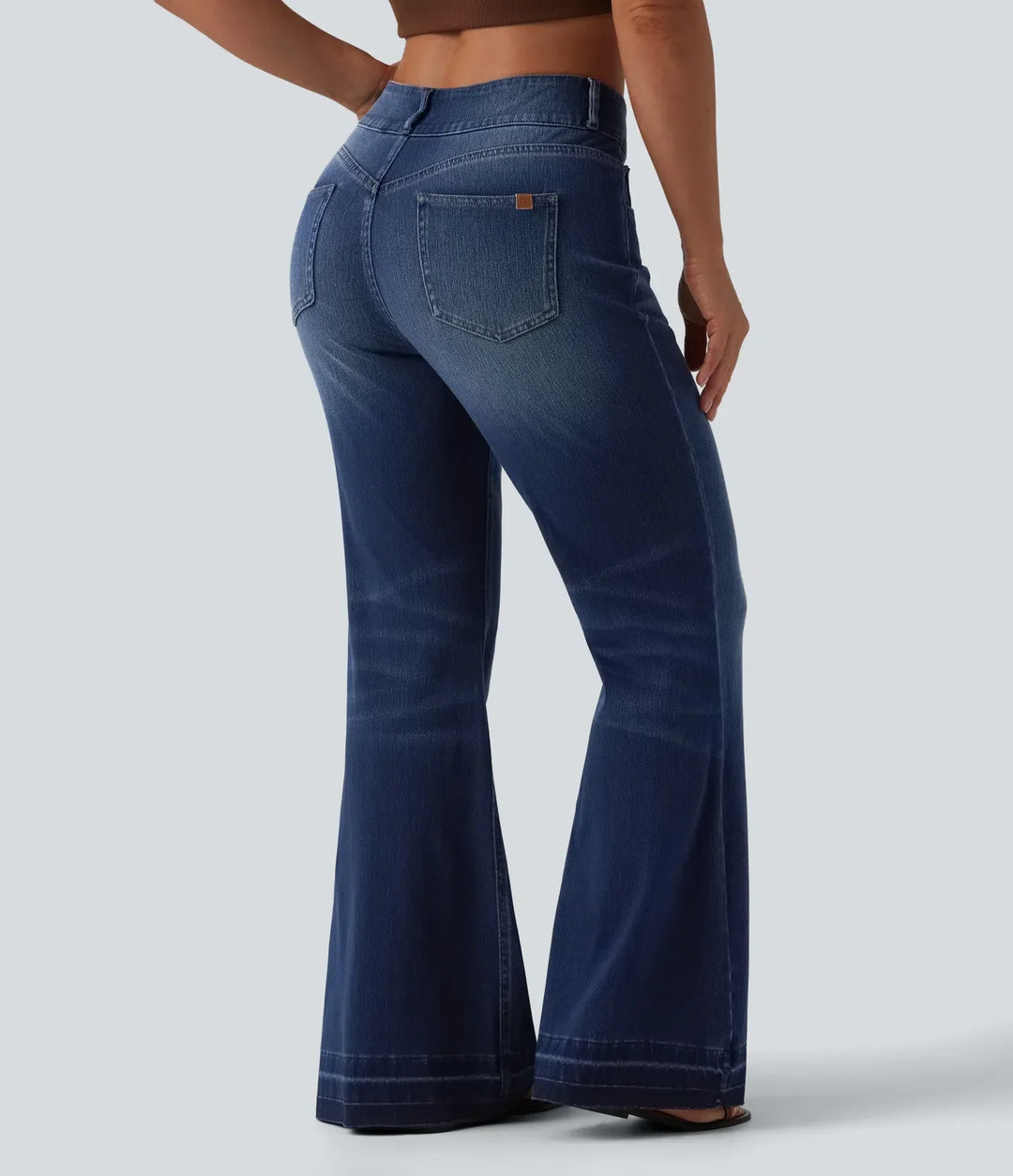 Moderna blå jeans för dam med utsvängda benslut, helfigur