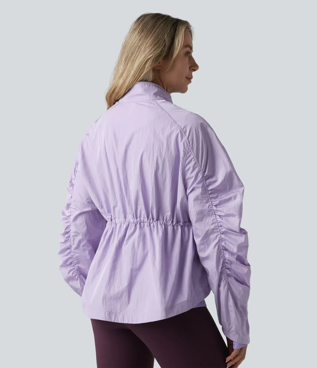 Baksidan av den lila jackan som visar den åtdragbara midjan