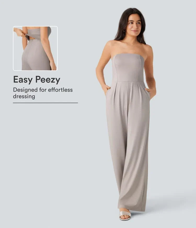 Dam i elegant axelbandlös grå jumpsuit med vida ben och fickor