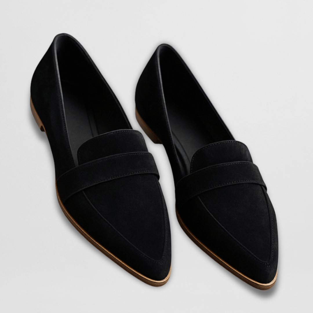 Svart par damloafers i mockaimitation mot ljus bakgrund