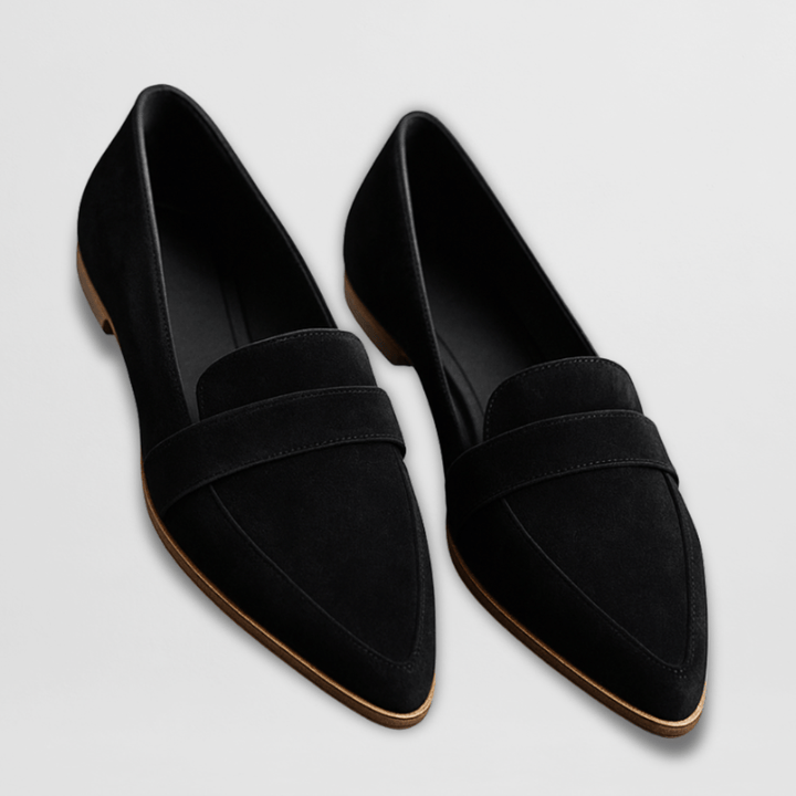 Svart par damloafers i mockaimitation mot ljus bakgrund