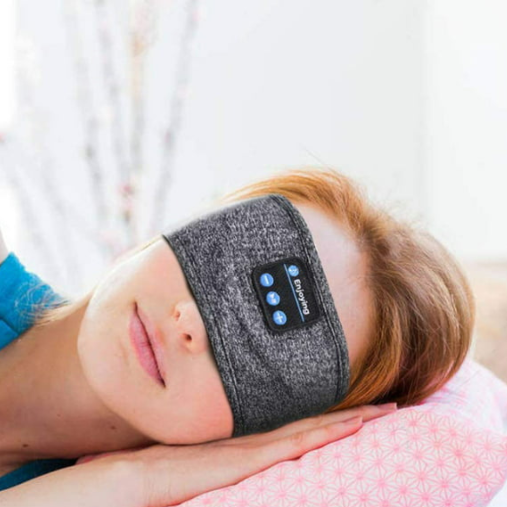 Person som vilar med grått bluetooth huvudband för sömn och musik