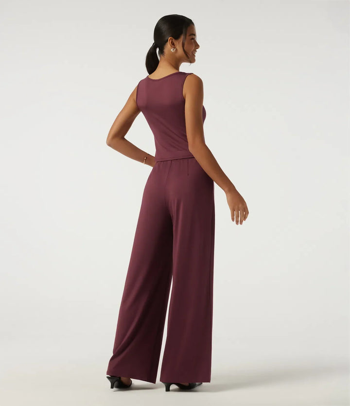 Närbild på tyget och den asymmetriska skärningen på jumpsuit för dam