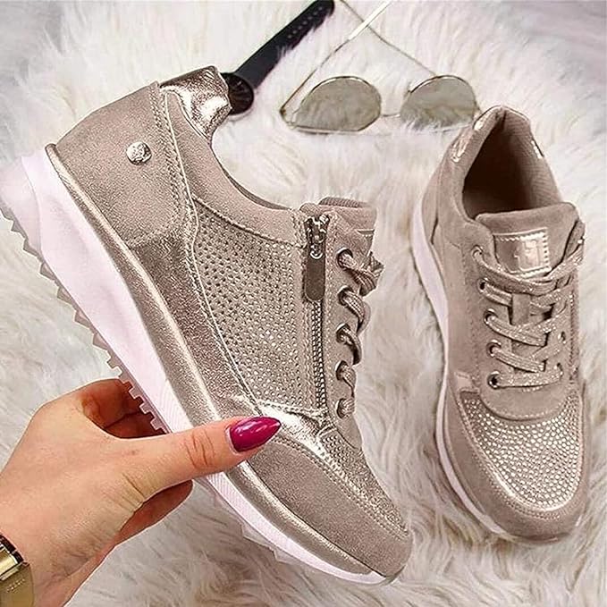 Närbild på beige kilklackssneakers med dekorativa detaljer