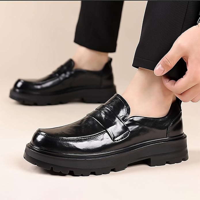 Svarta slip-on loafers med moccasin-tå på fot