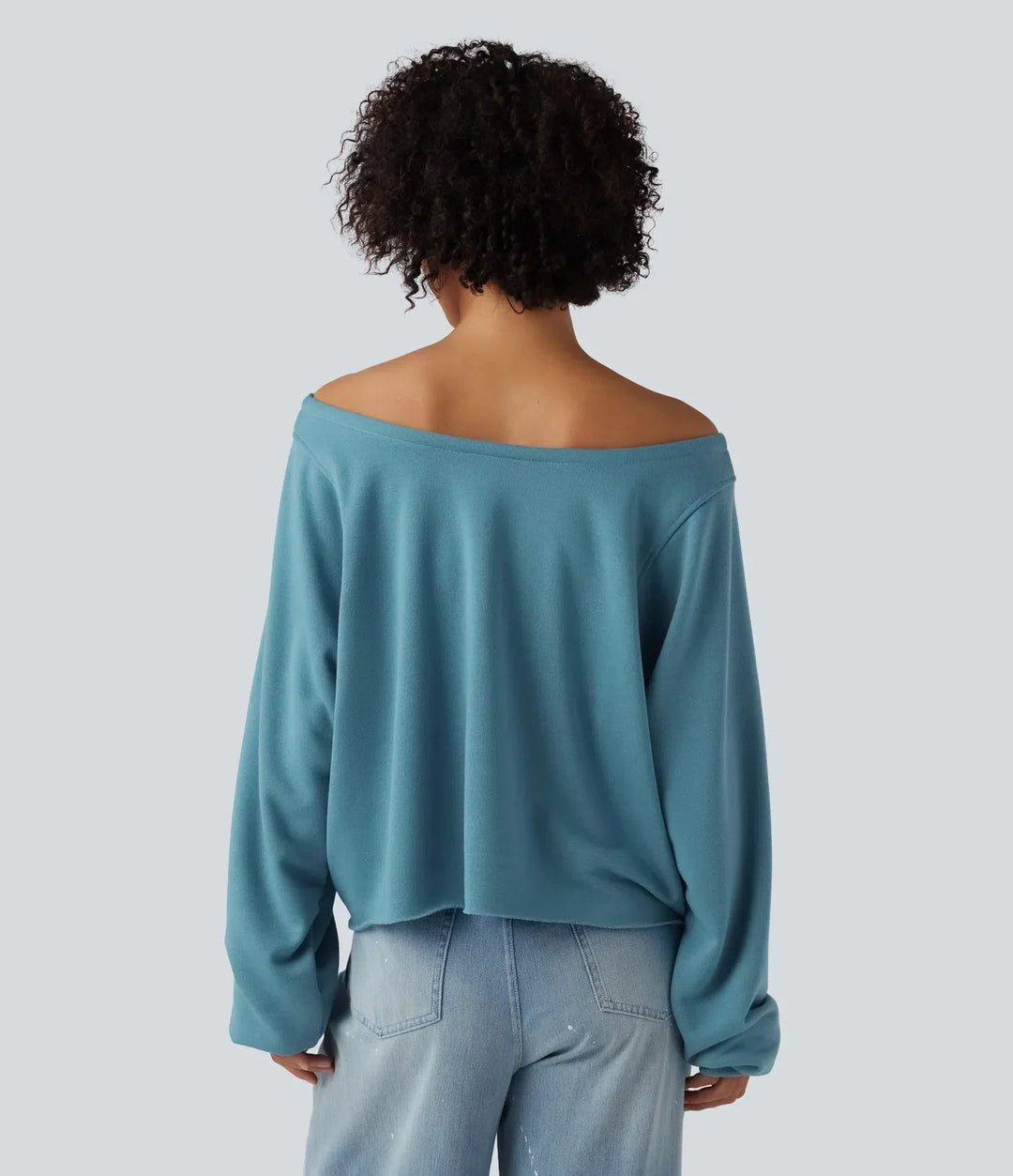 Baksidan av en blå långärmad sweatshirt med off-shoulder design