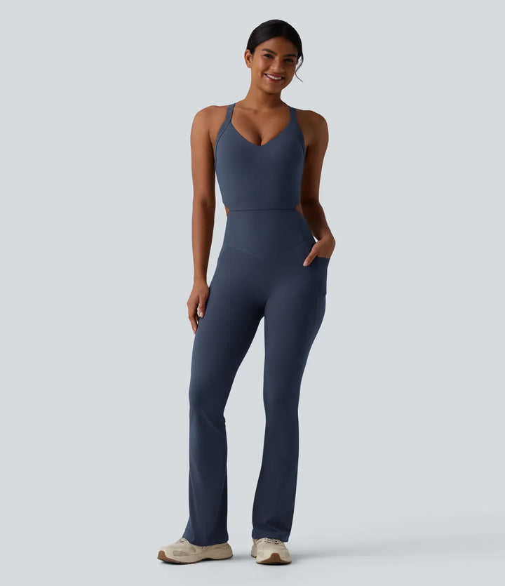 Framsidesvy av blå träningsjumpsuit med bootcut och fickor för dam