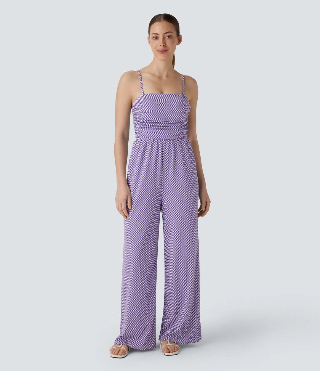 Framifrån på dam i rutig lila jumpsuit med justerbara remmar