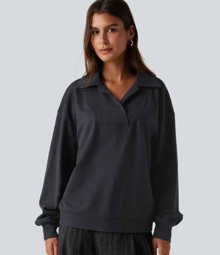 Kvinna i mörkgrå sweatshirt med V-ringning framifrån