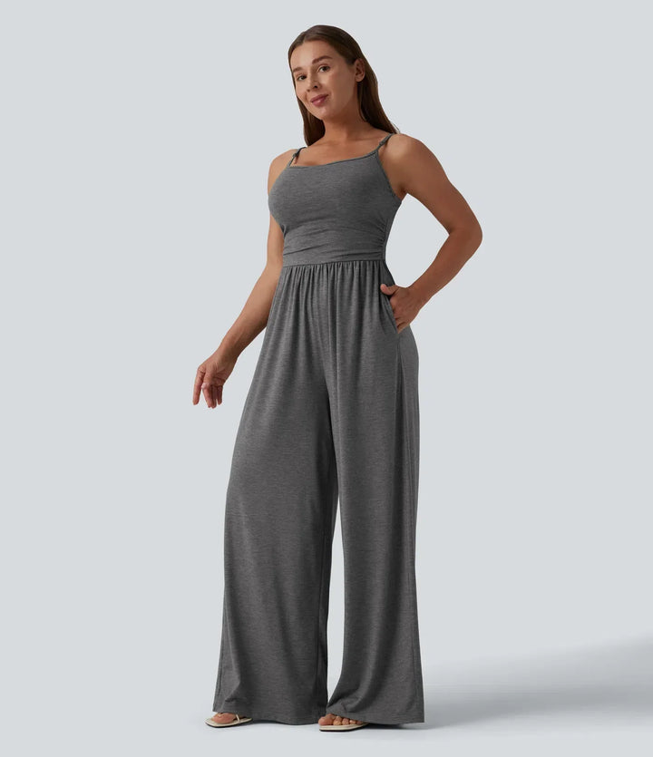 Snett framifrån av kvinna i grå vardagsjumpsuit med rynkad midja