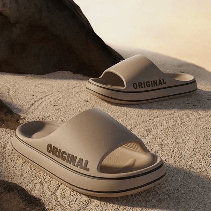 Beige tofflor med tjock sula utomhus på sand