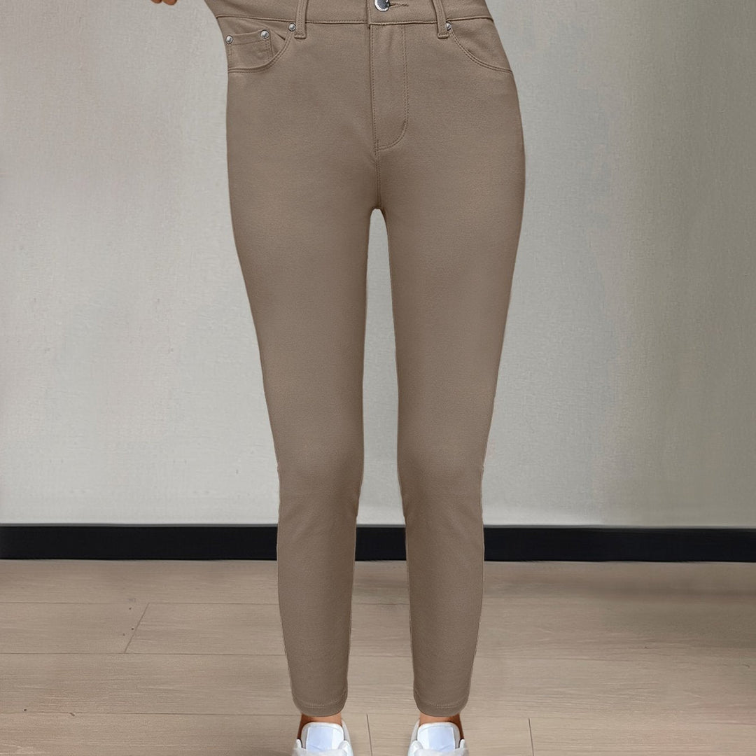 Närbild på fickdetalj och metallnitar på stretchjeans
