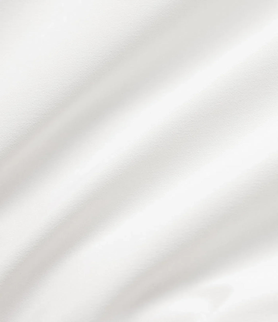 Närbild på textur och dragkedja på vit vadderad jacka för damer.