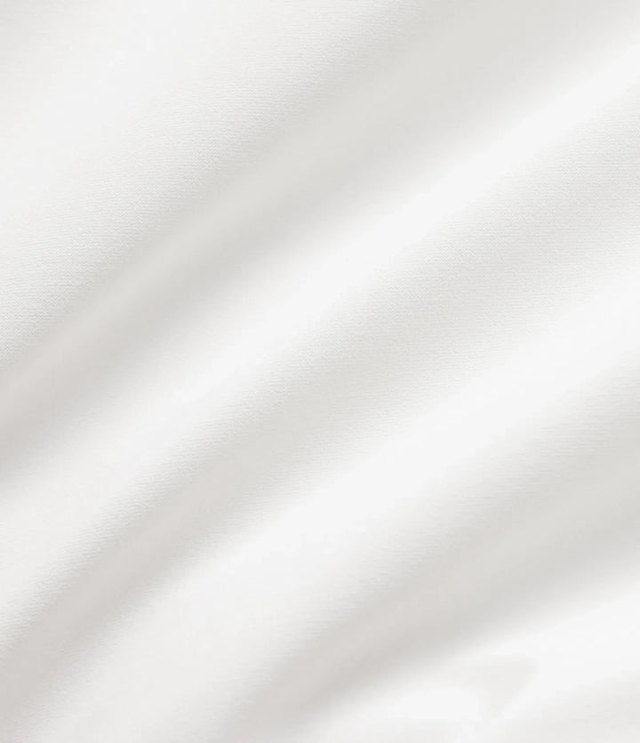 Närbild på textur och dragkedja på vit vadderad jacka för damer.
