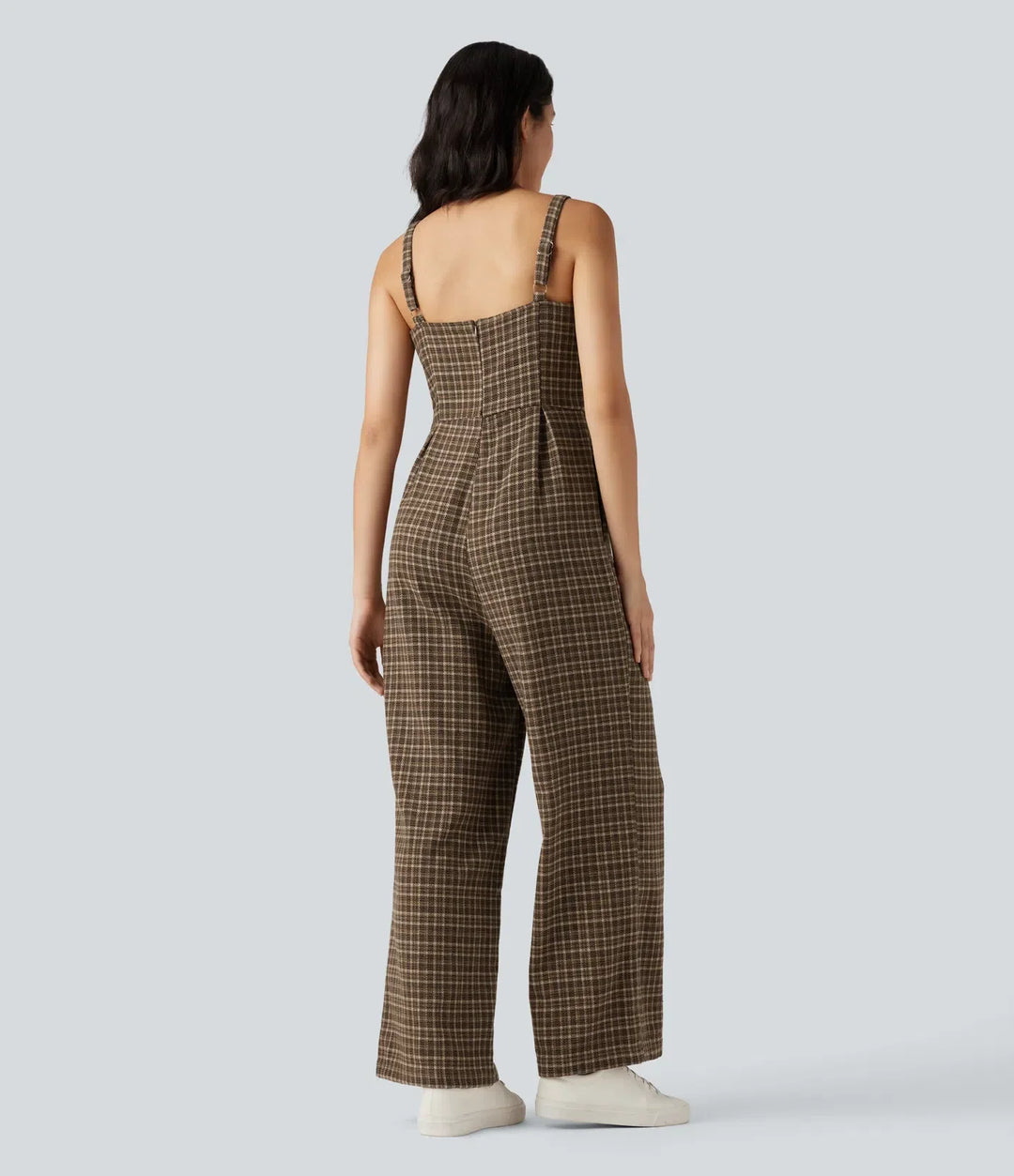 Kvinna bakifrån som visar passformen på den rutiga jumpsuiten med vida ben
