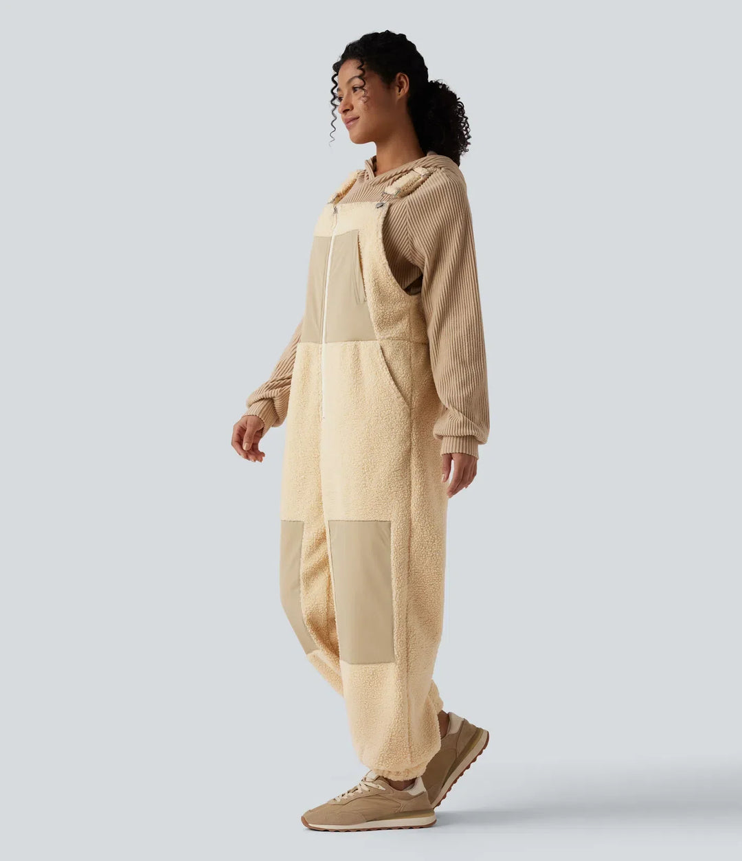 Profilvy av dam i beigefärgad sherpaoverall med fickor