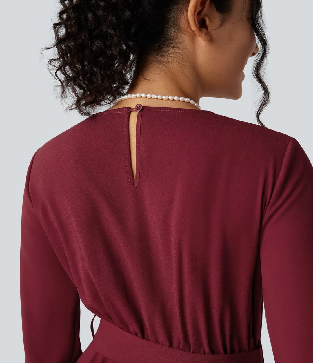 Stilren v-ringad jumpsuit med långa ärmar sedd från sidan