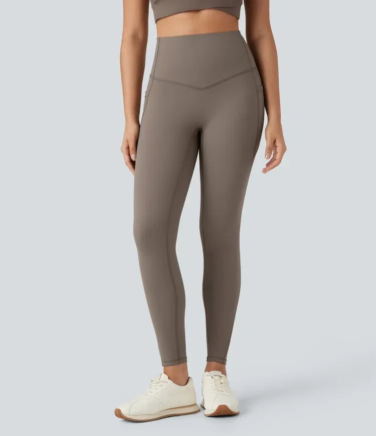 Framsidebild på kvinna som bär bruna högmidjade fleece yogaleggings med fickor