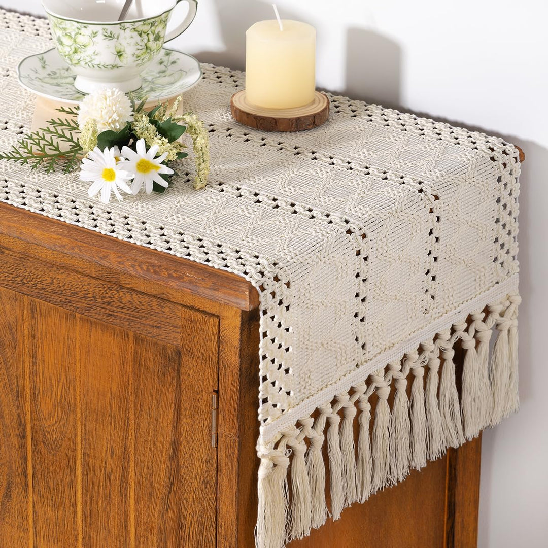 Boho macrame bordslöpare på ett skåp dekorerad med ljus och blommor