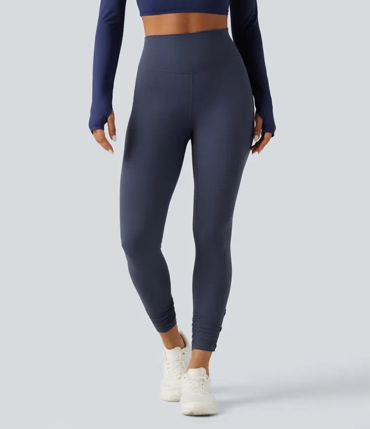 Framifrån av mörkblå yogaleggings som visar den höga midjan och passformen