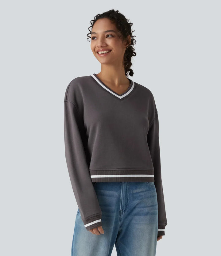 Kvinna som ler iförd mörkgrå sweatshirt med färgblock