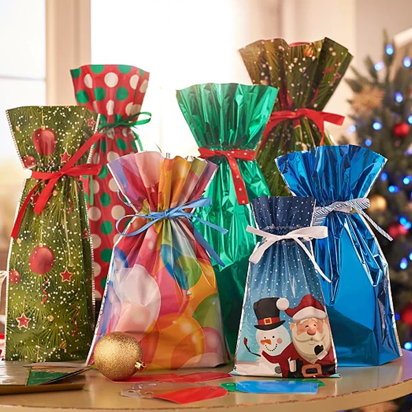 Färgglada och mönstrade julklappspåsar uppställda runt en julgran