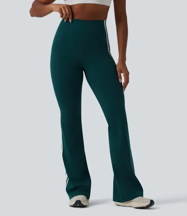 Helbild framifrån av dam i mörkgröna utsvängda yogaleggings